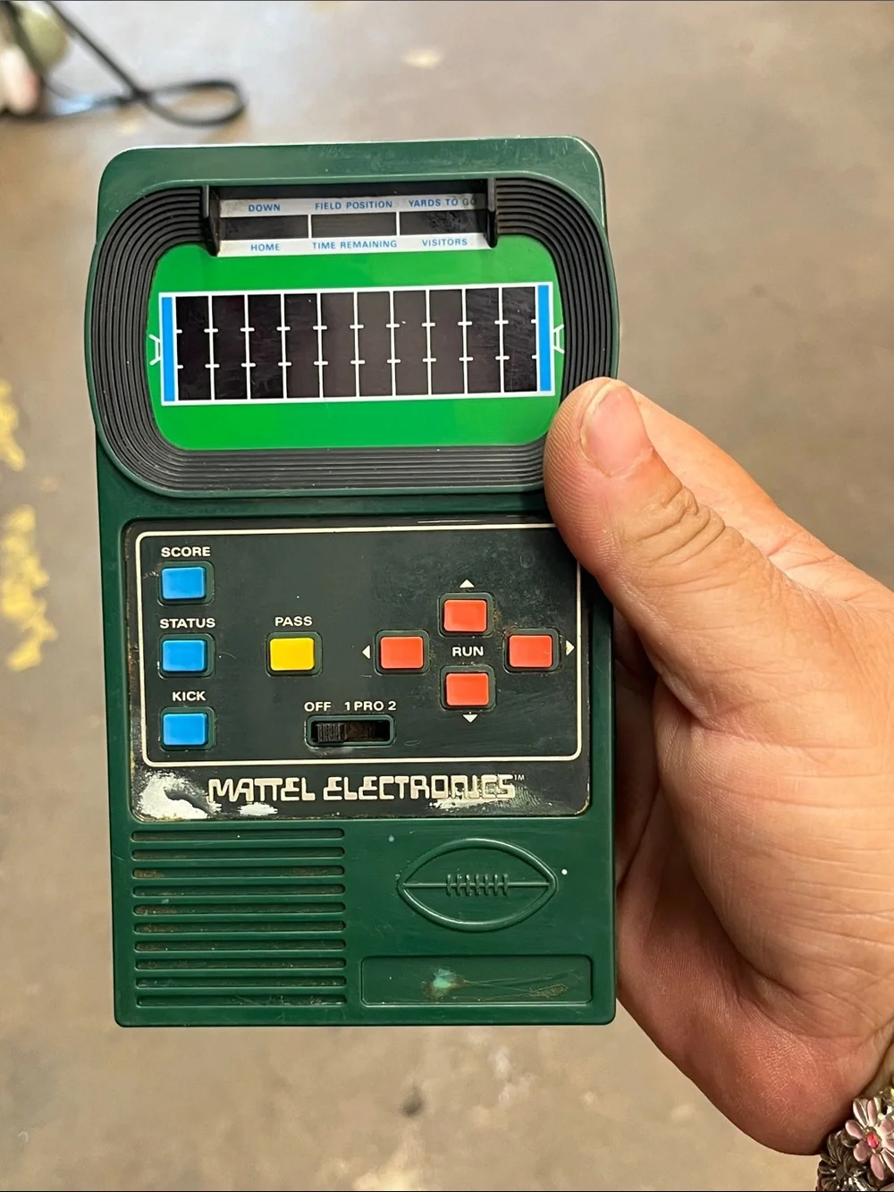 Mattel Green Handheld Electronic Football Game with Blue Yellow Orange Buttons